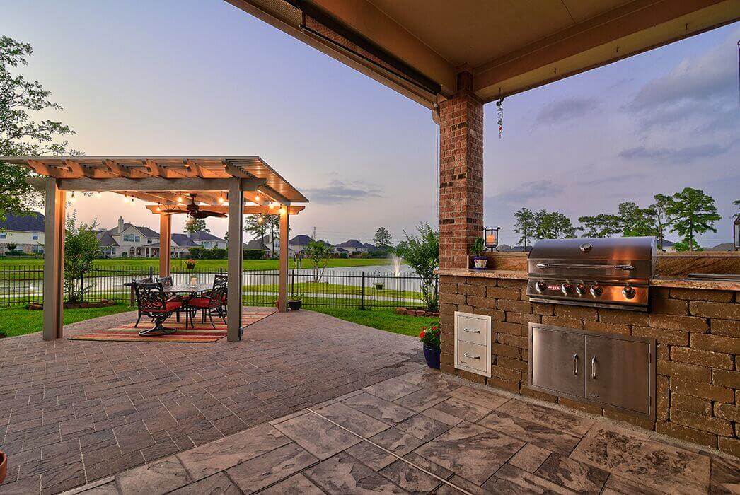 Paver patio with grill and pergola string lights design inspiration