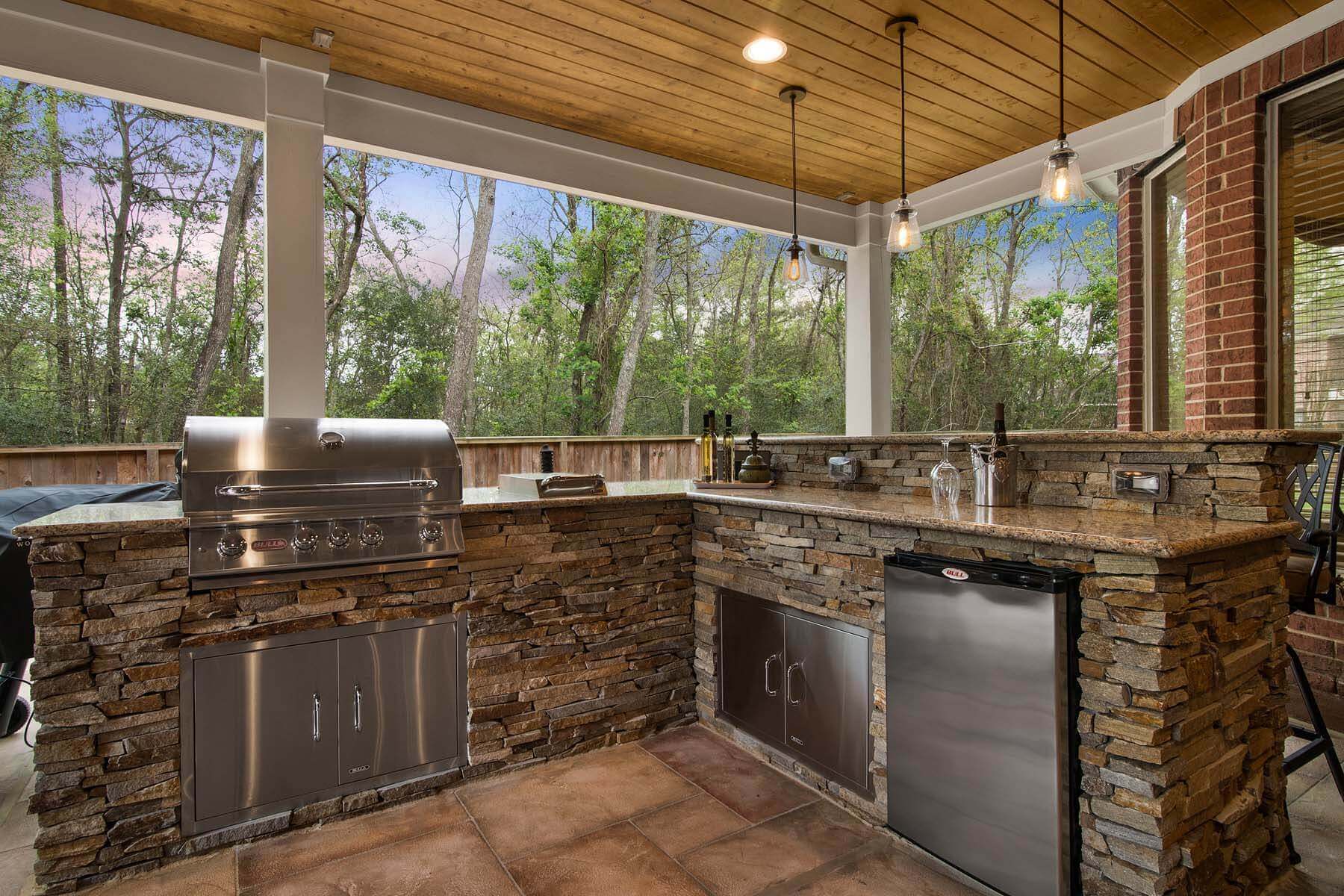 Outdoor kitchen and sink setup in a backyard covered patio