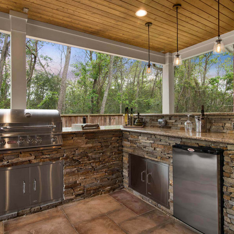 Outdoor kitchen and sink setup in a backyard covered patio
