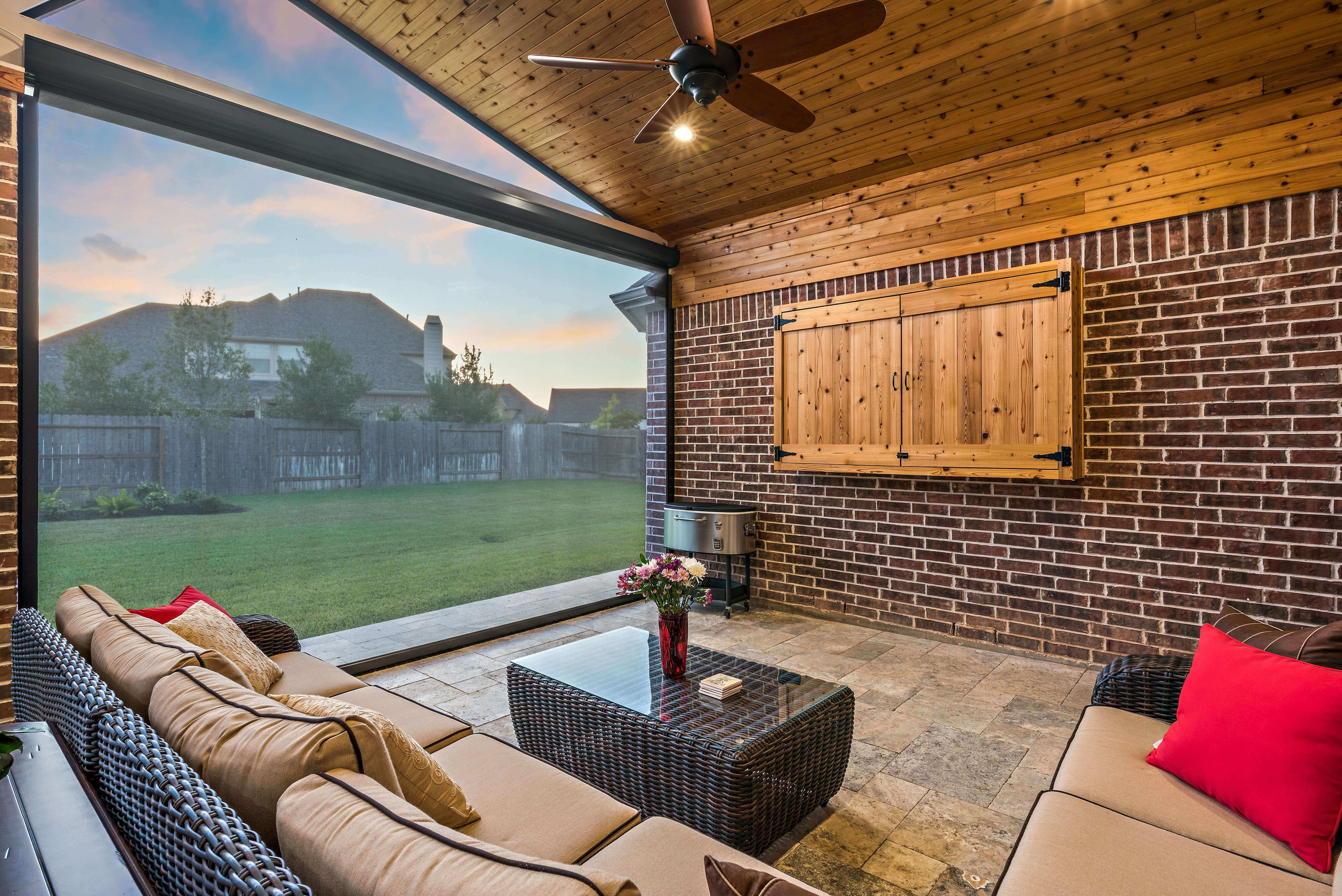 Covered patio extension with screens, fan and tv mount for backyard entertaining.