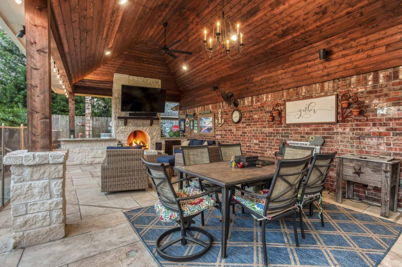 Outdoor living room area with tv mount and backyard dining area