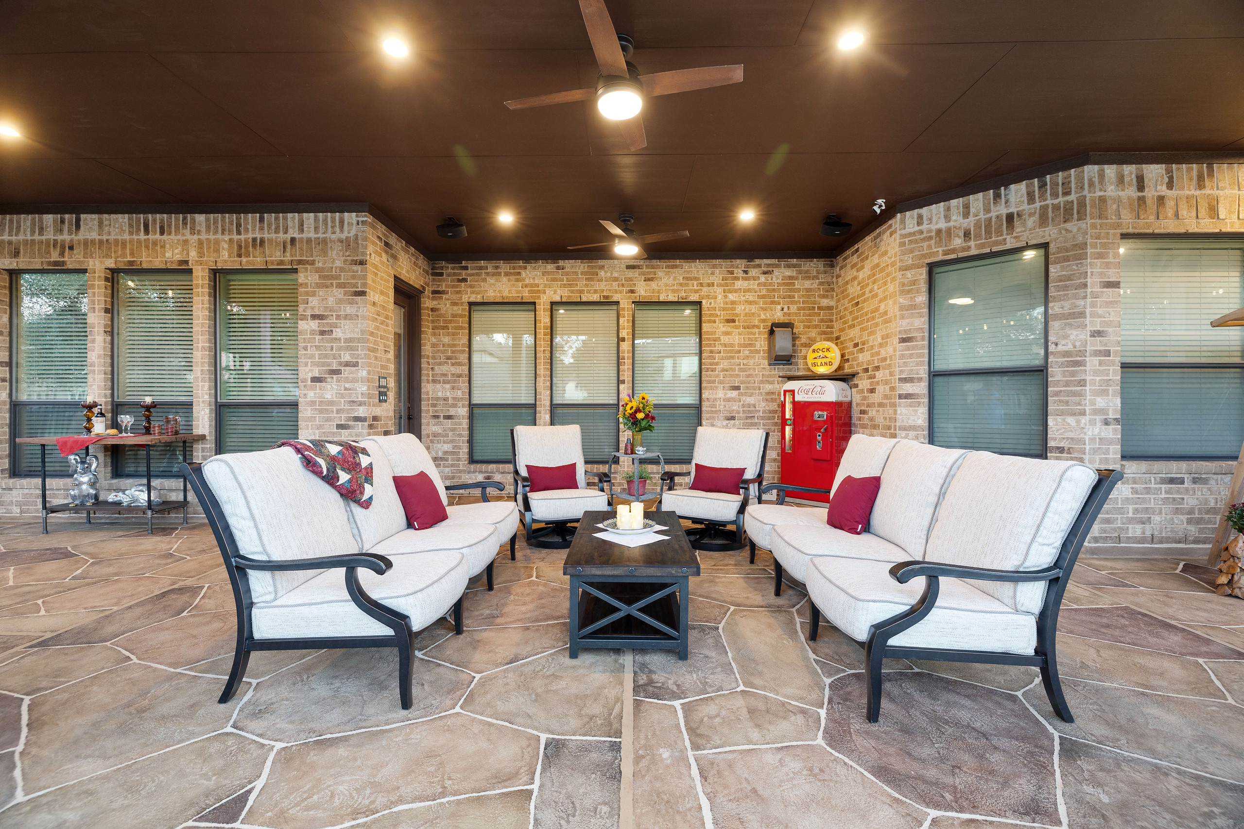 Backyard seating area underneath covered patio with carvestone overlay