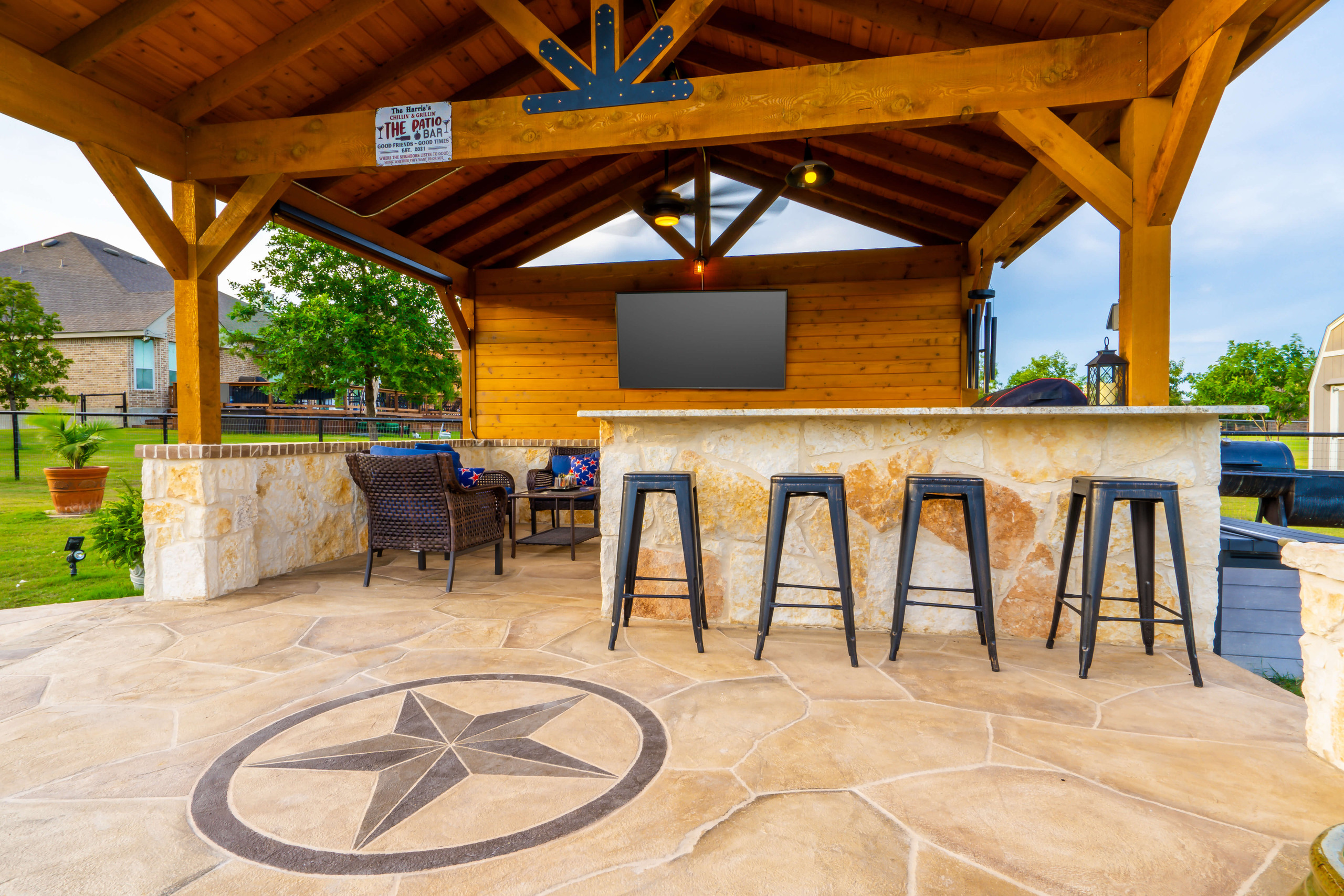 Cedar covered patio and bar area with carvestone and texas star design