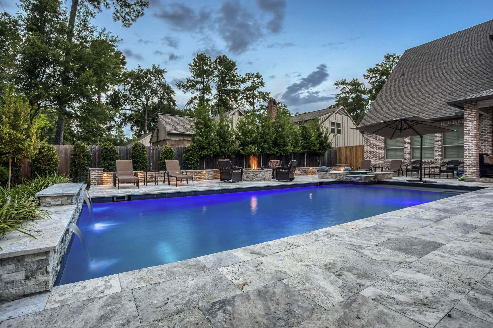 Luxury backyard pool and travertine decking