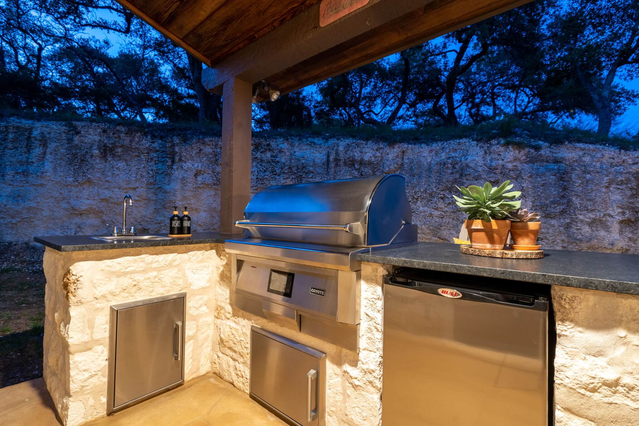 outdoor kitchen grill setup stone facade backyard patio remodel