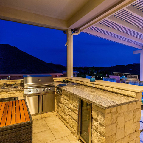 stone kitchen bar seating outdoor living space pergola privacy wall