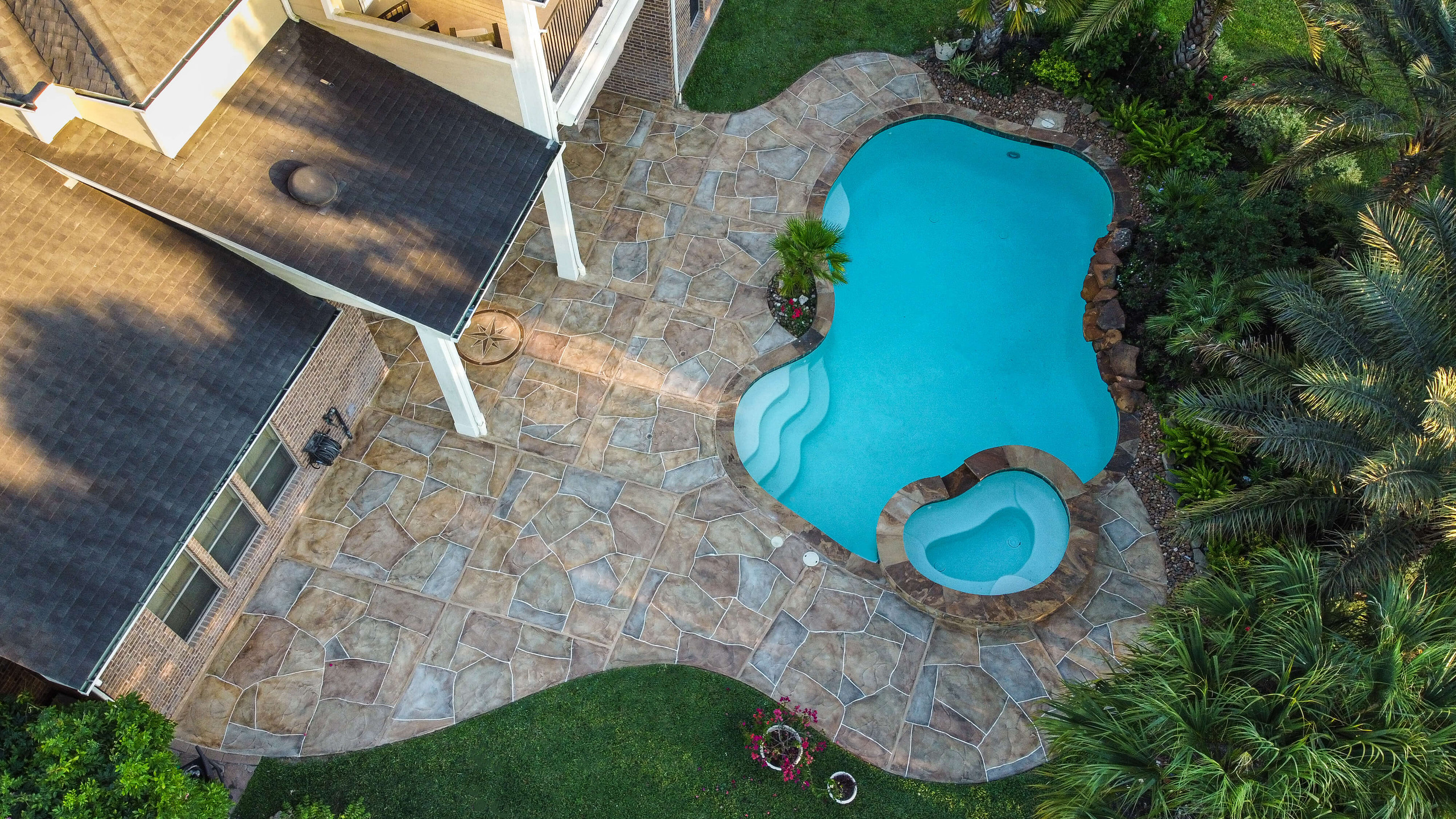 Carvestone around backyard pool to enhance patio design idea