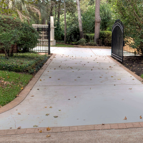 Concrete driveway hardscape in Texas with brick border design idea