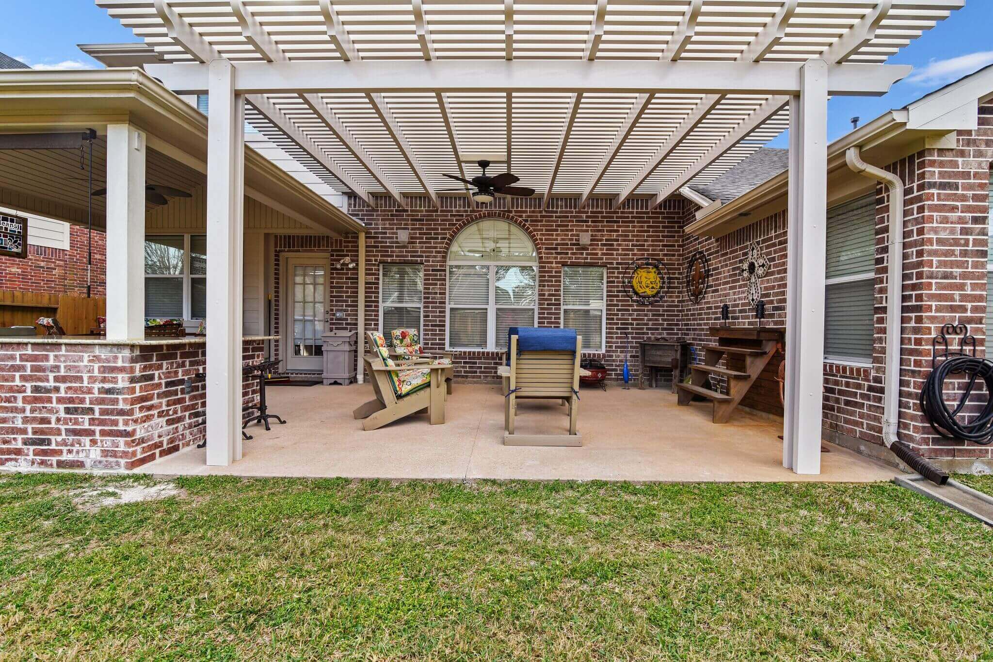 Shaded white pergola over backyard patio