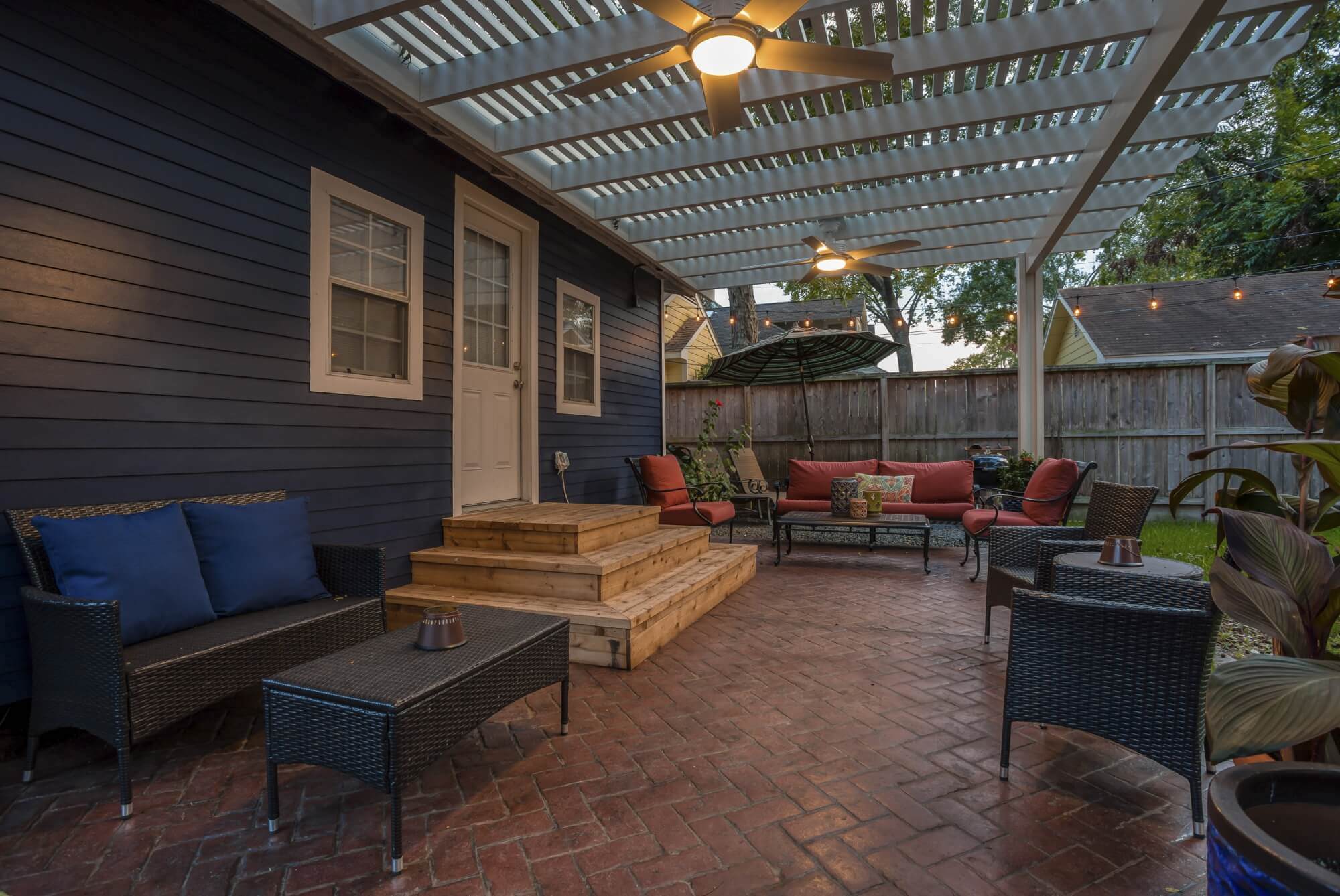 Backyard makeover with white pergola and stamped concrete patio extension