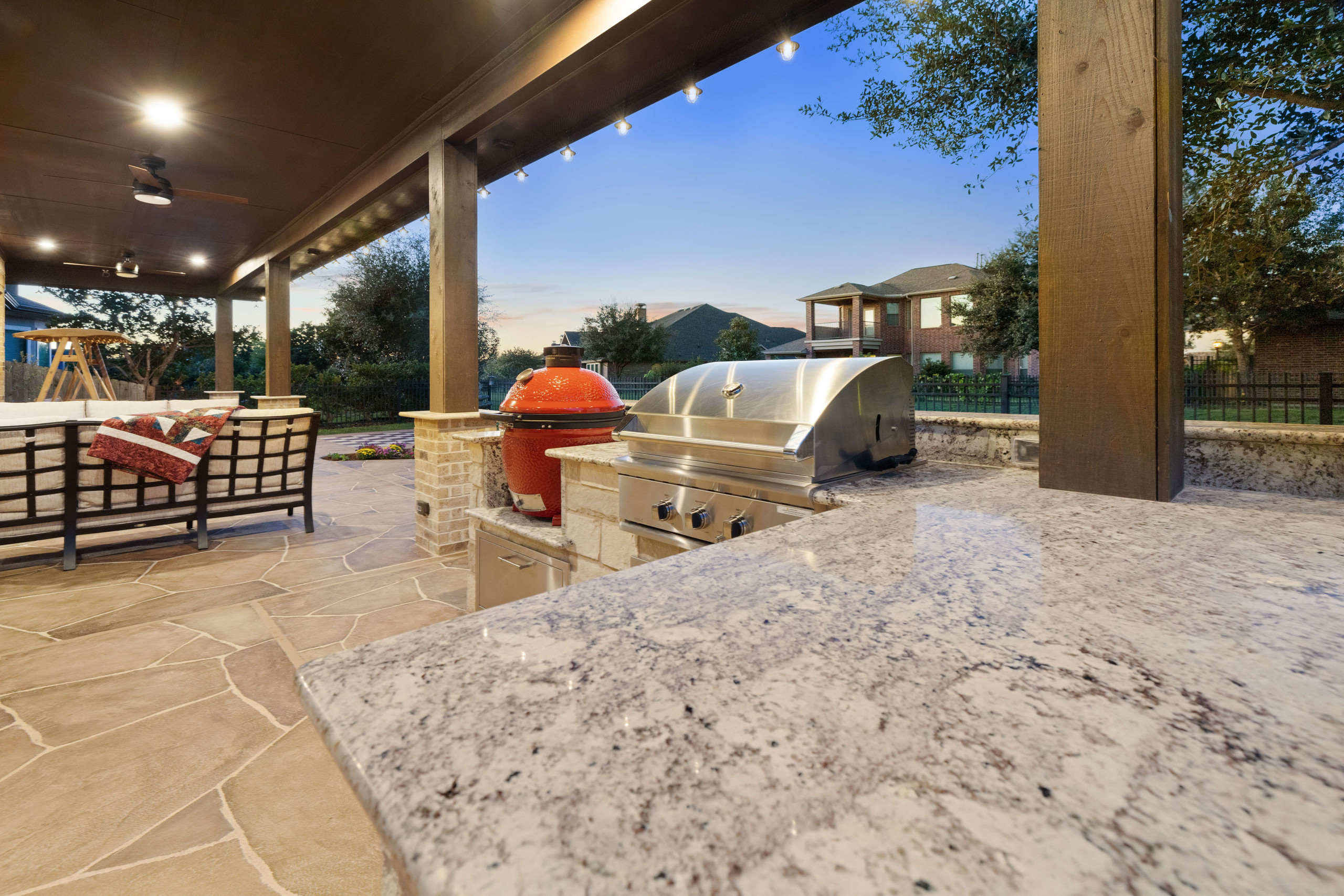 Modern outdoor kitchen with granite countertop, smoker, and grill