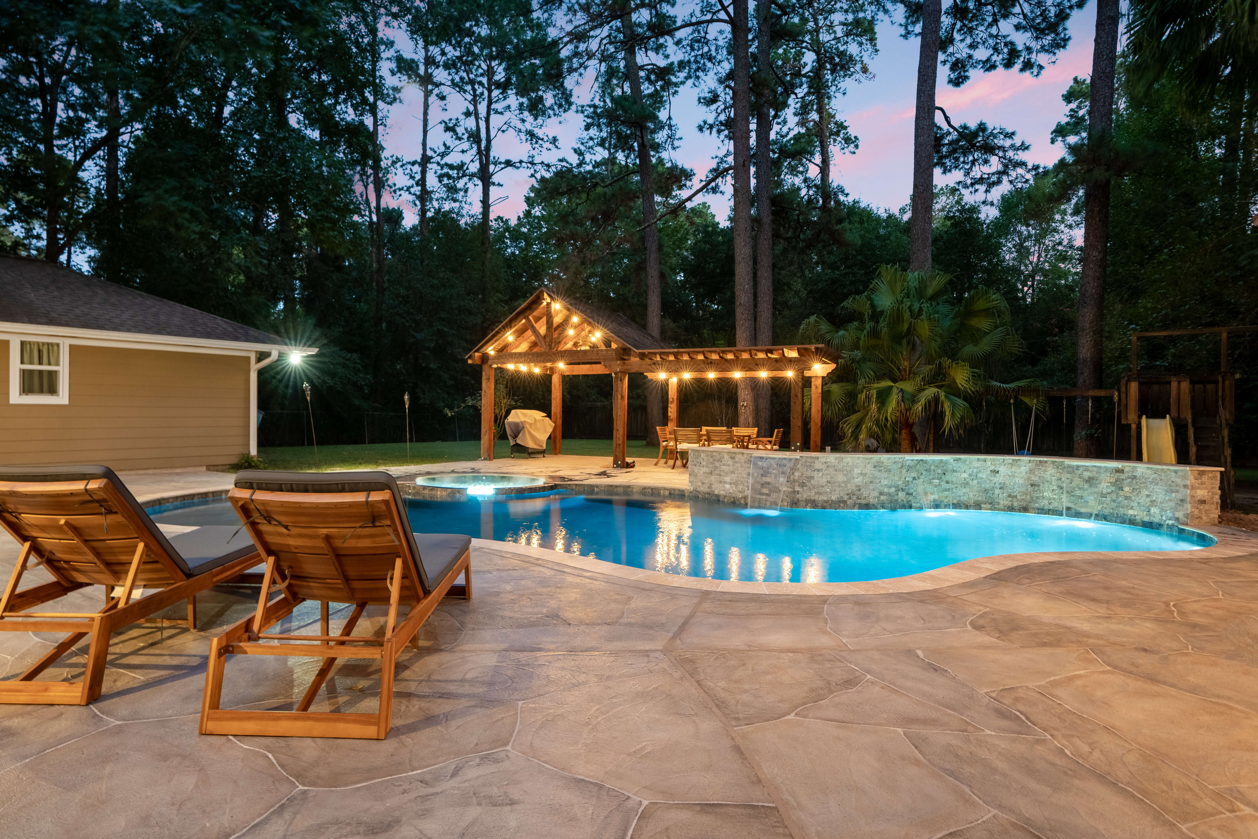 Backyard pool with pergola structure and water feature and pool design idea