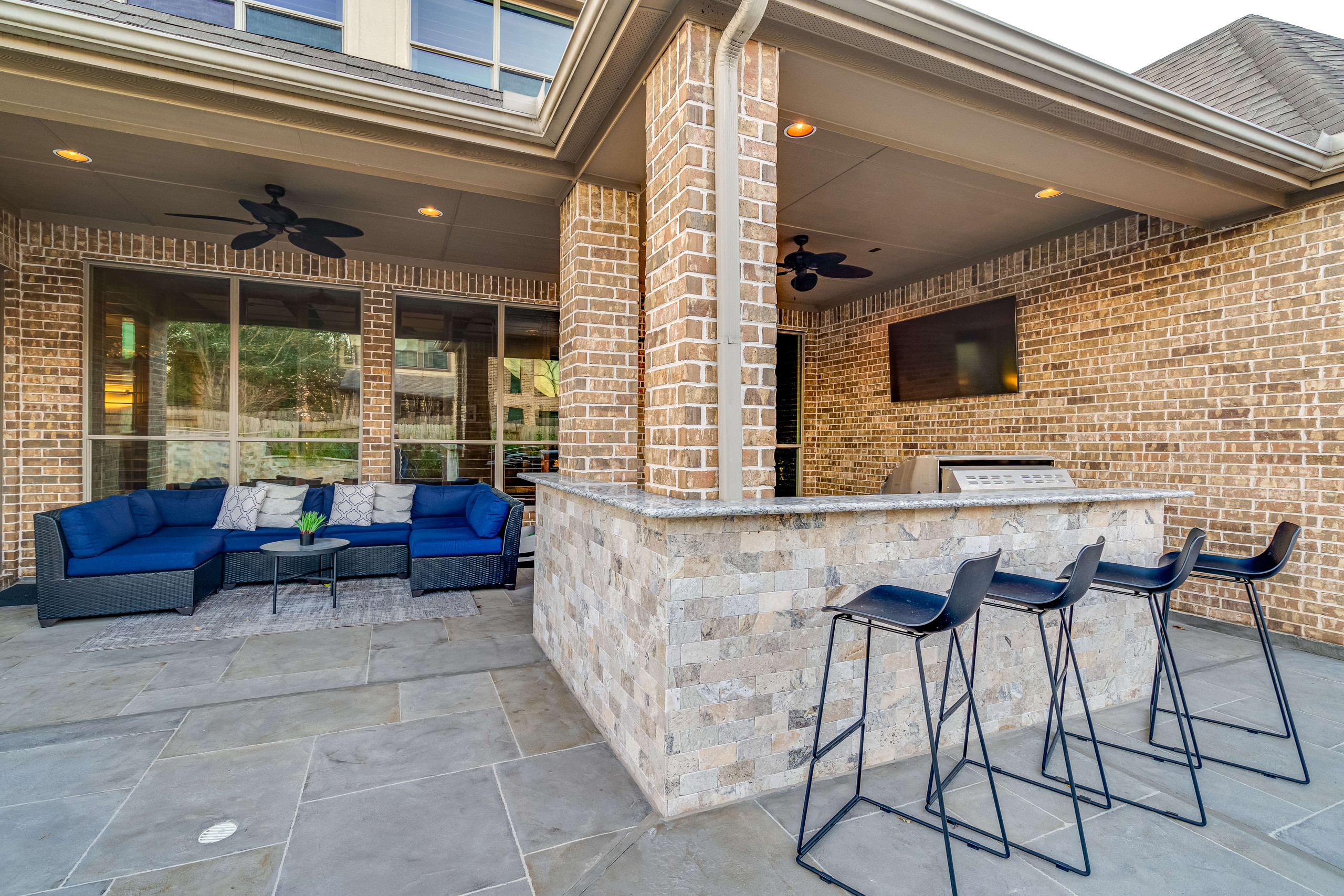 Stone detailing on an outdoor countertop with bar stools