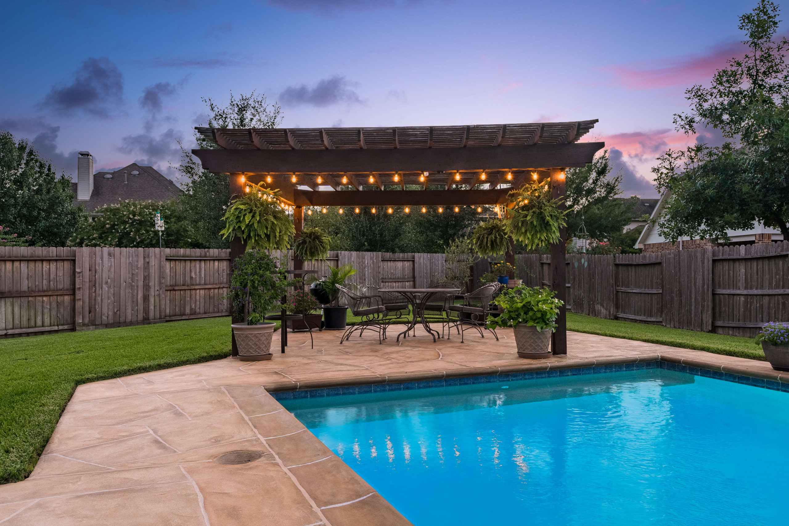 Wooden pergola and seating area poolside with carvestone decking