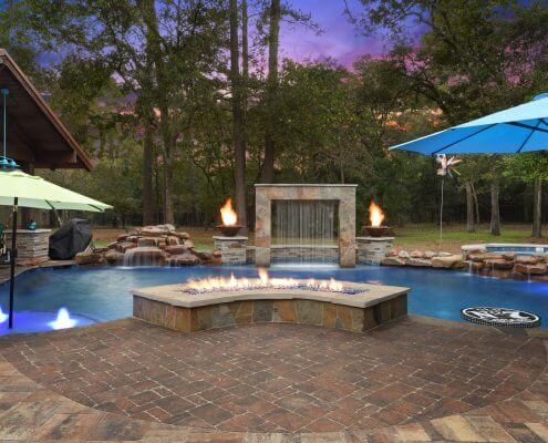 Pool remodel with fire feature and water fountain backyard design idea