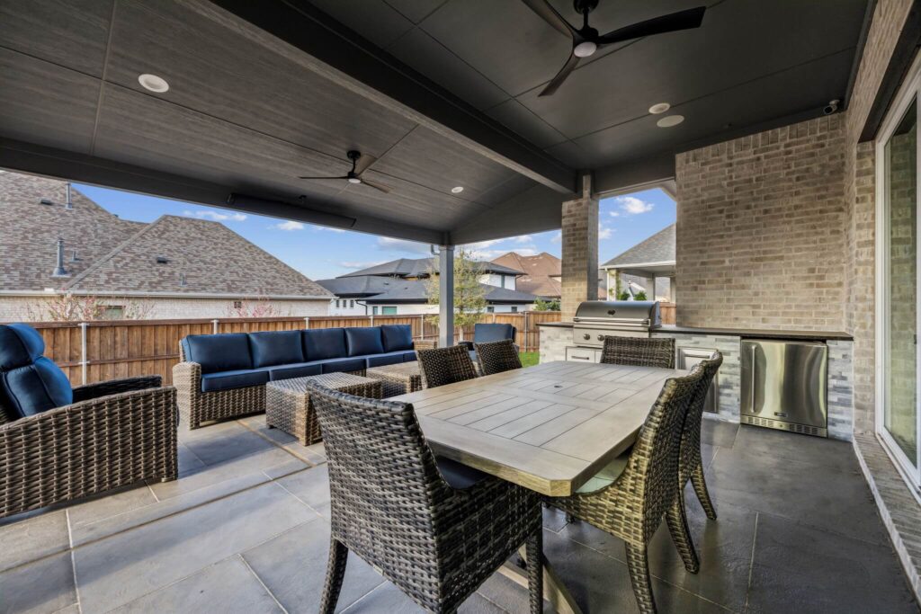 Outdoor kitchen with stone island under a covered patio