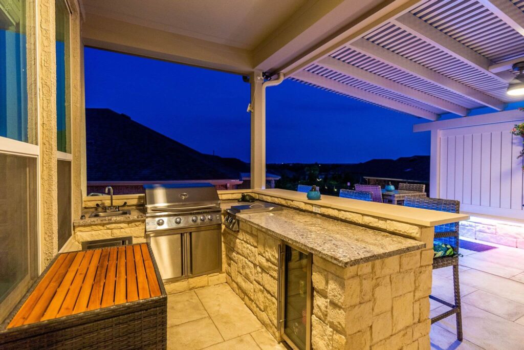 Outdoor kitchen with wood counter under covered patio