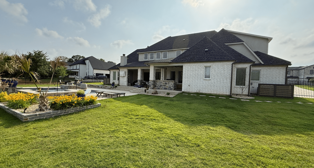 Large backyard patio and pool deck with lawn, landscaping, and covered seating area