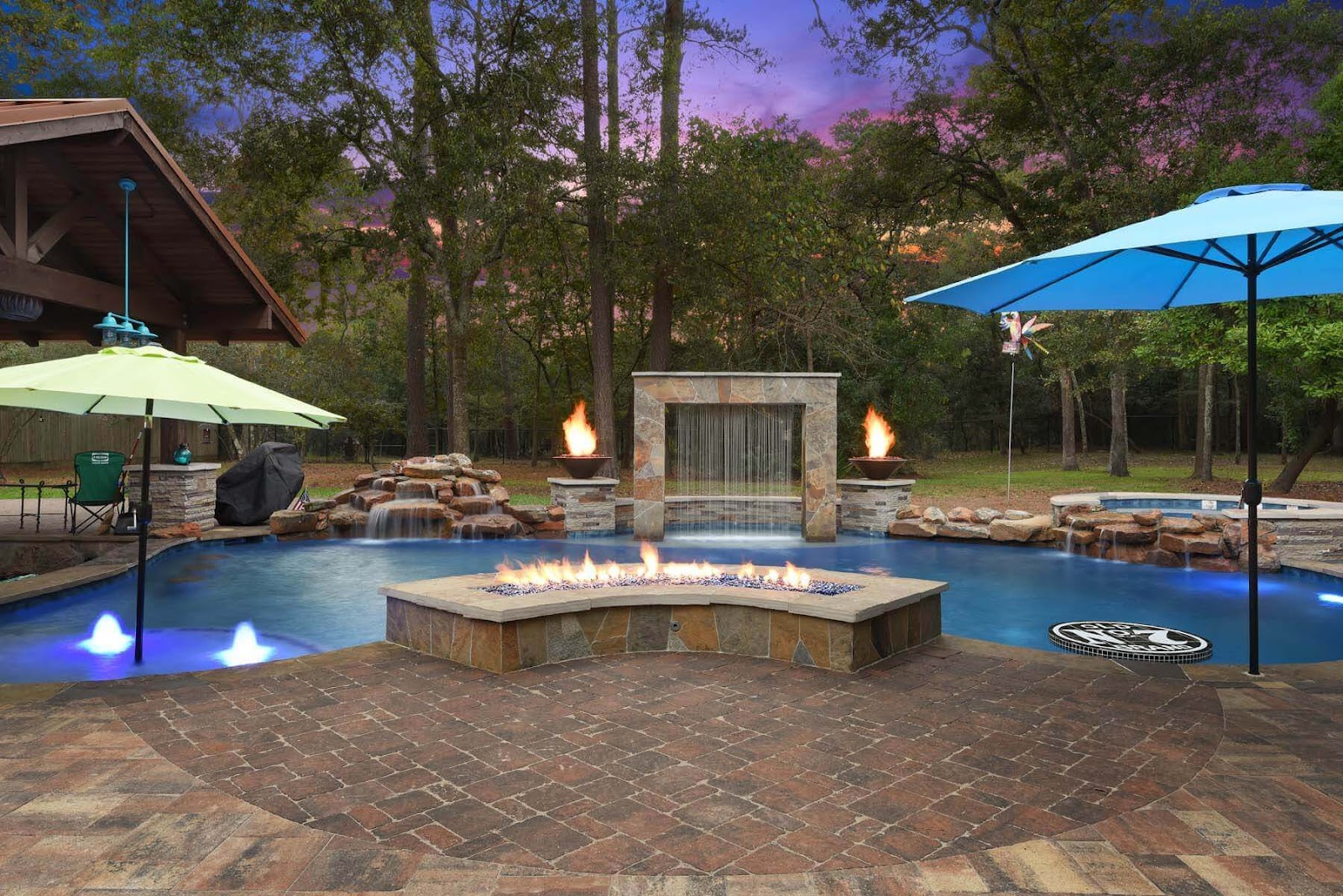 brick paver pool deck with inground pool, rain curtain and custom fire pit