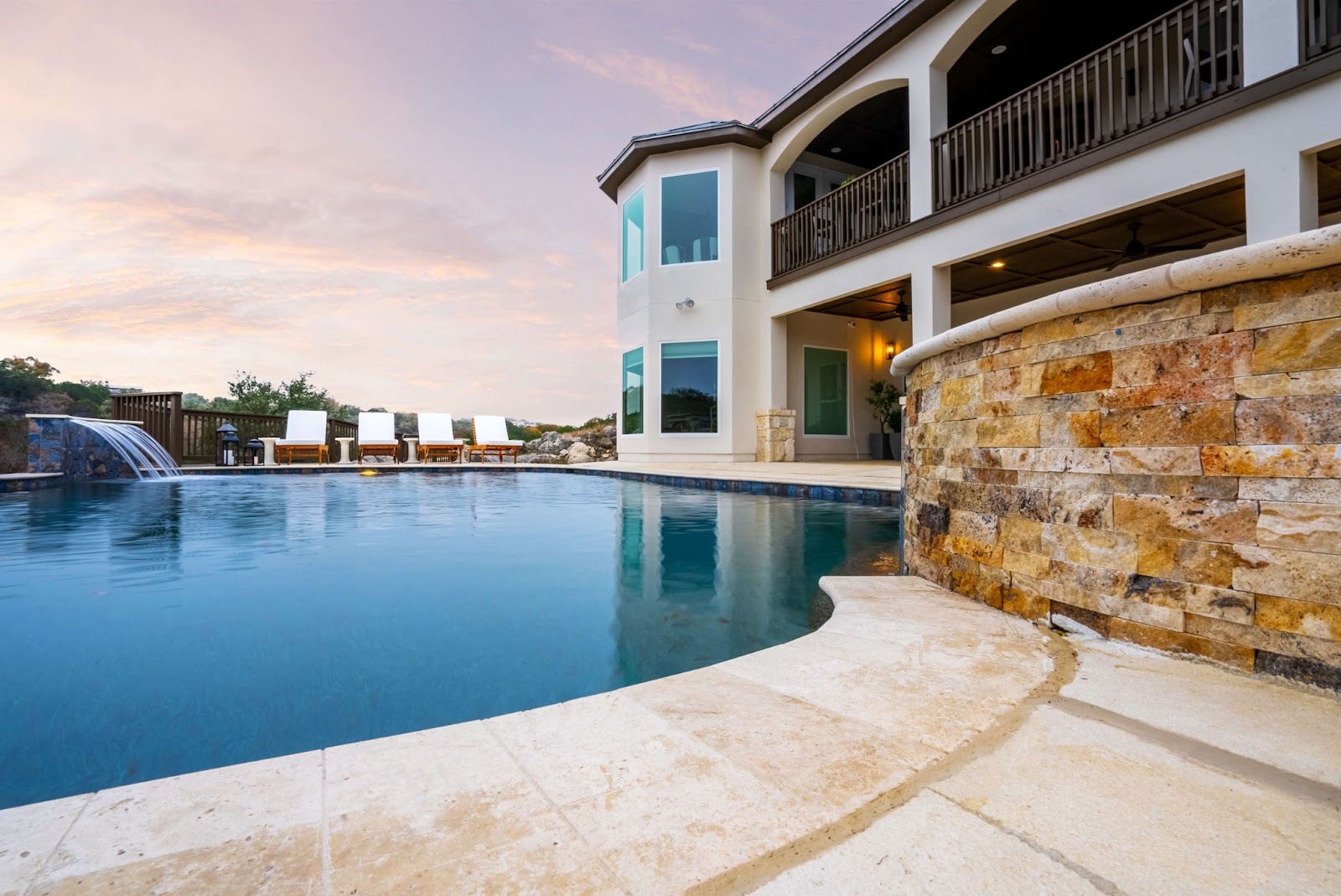 texas pool remodel with custom water feature and carvestone pool deck