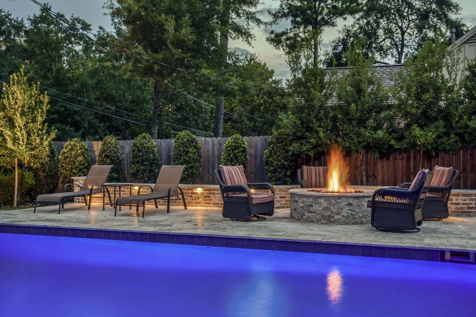 poolside natural stone fire pit with outdoor seating and premium pool deck