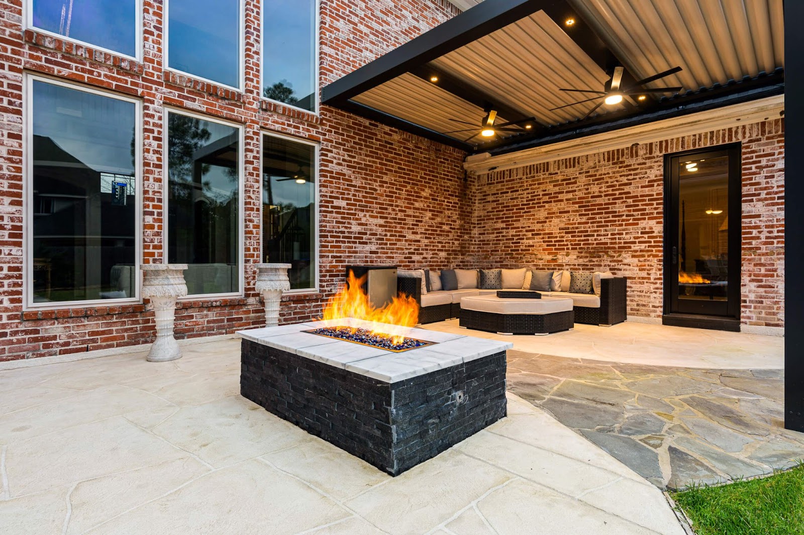 custom covered patio and fire pit design with natural stone, brick and concrete materials
