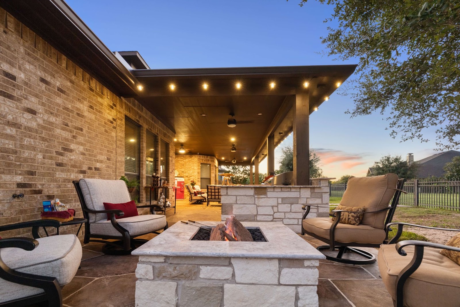 rustic texas stone patio hangout space with custom stone fire pit and brick architecture