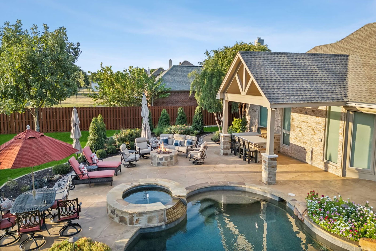 full seamless outdoor living design with covered patio, pool deck, hot tub and pool