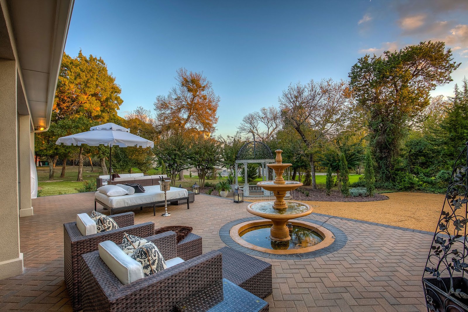 brick paver patio with fountain and seating area in texas backyard