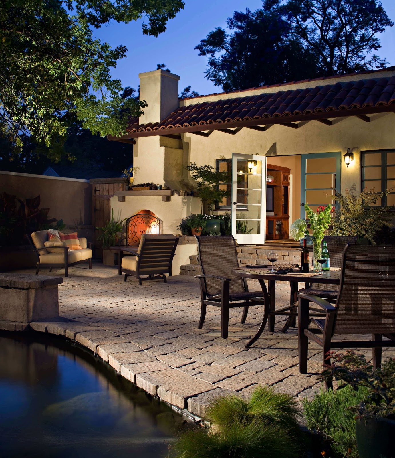 rustic backyard spanish style patio with outdoor fireplace and brick pavers