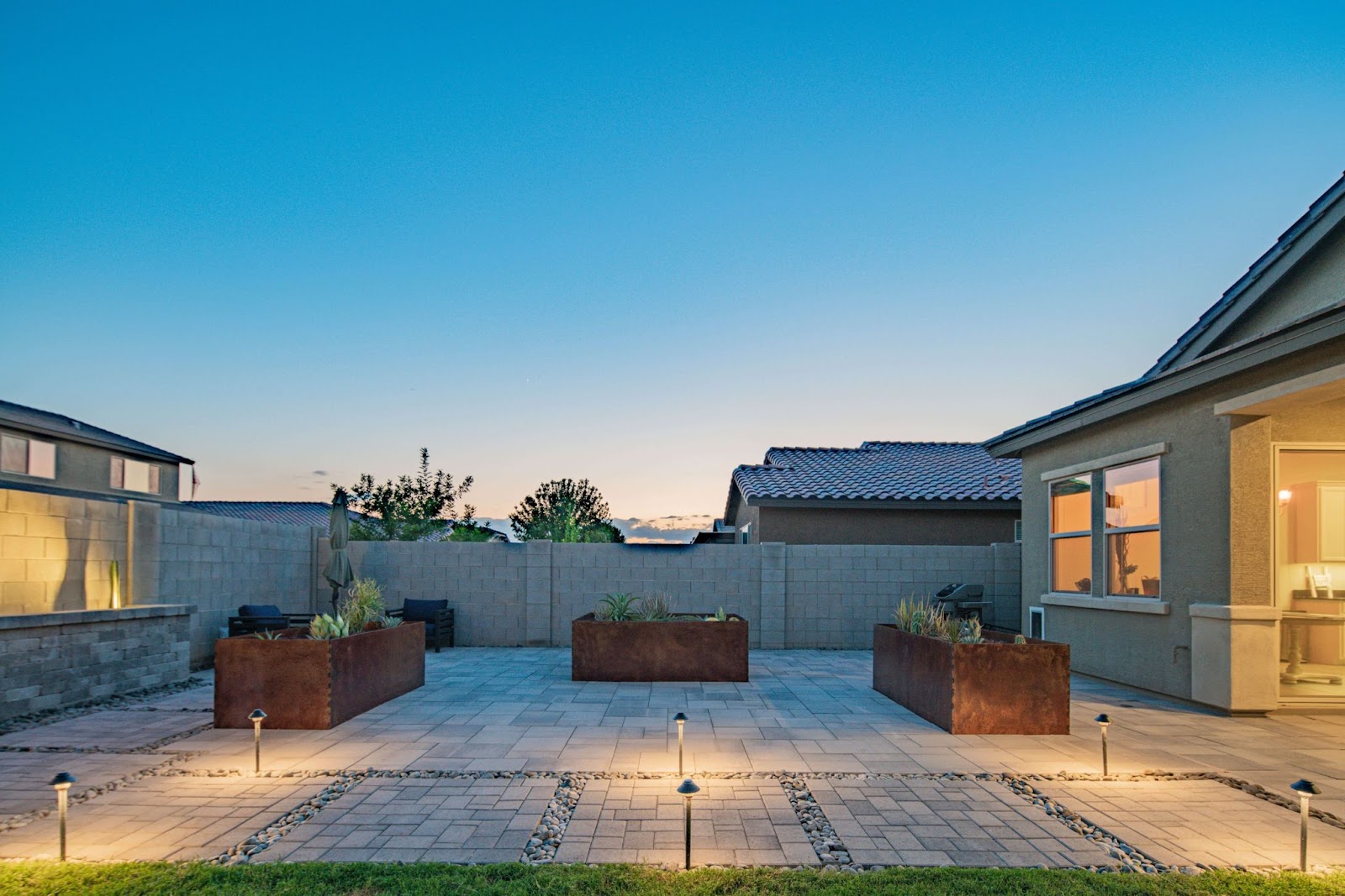 geometric minimal outdoor patio design with large planters and accent lighting