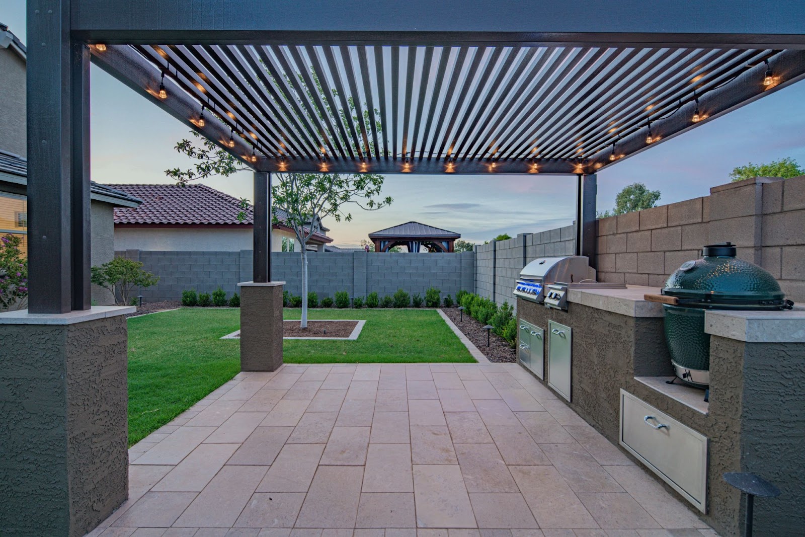 premium backyard pergola with metal slatted roof and custom grill stations