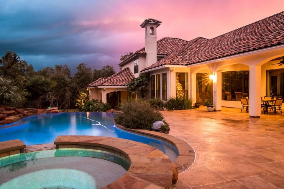 terra cotta concrete pool deck overlay with inground pool at spanish style villa in tx