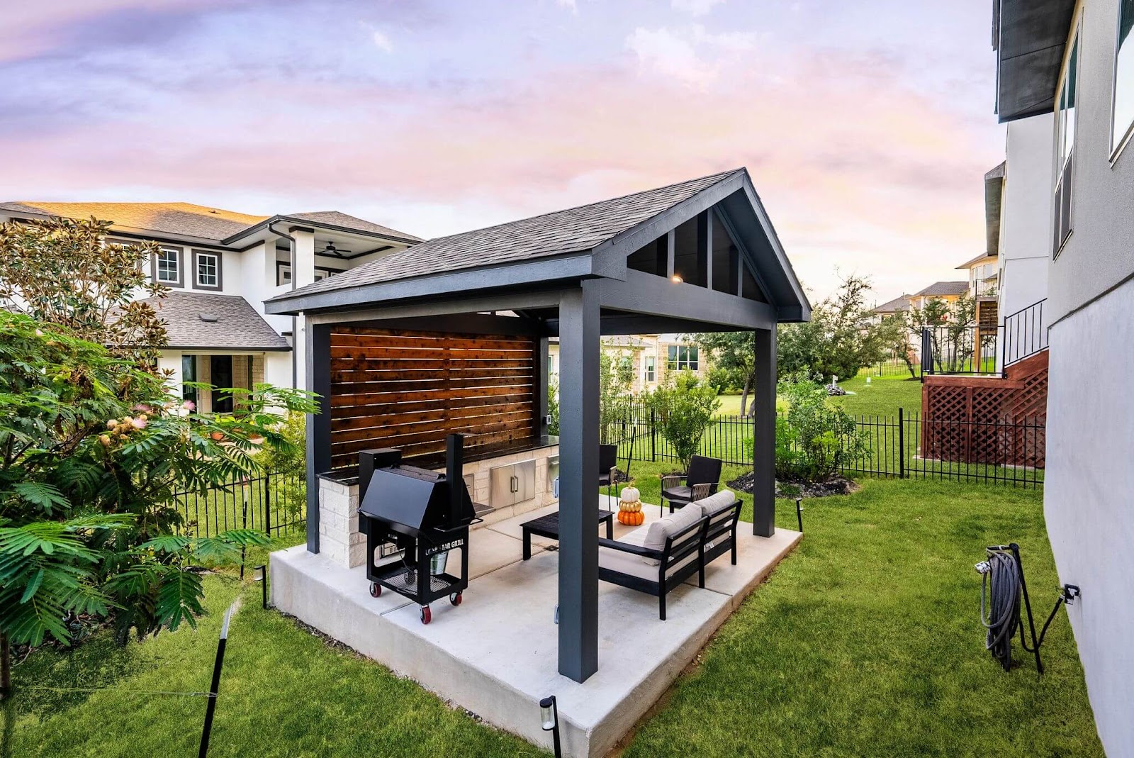 detached covered patio with outdoor grill and seating, privacy wall and storage