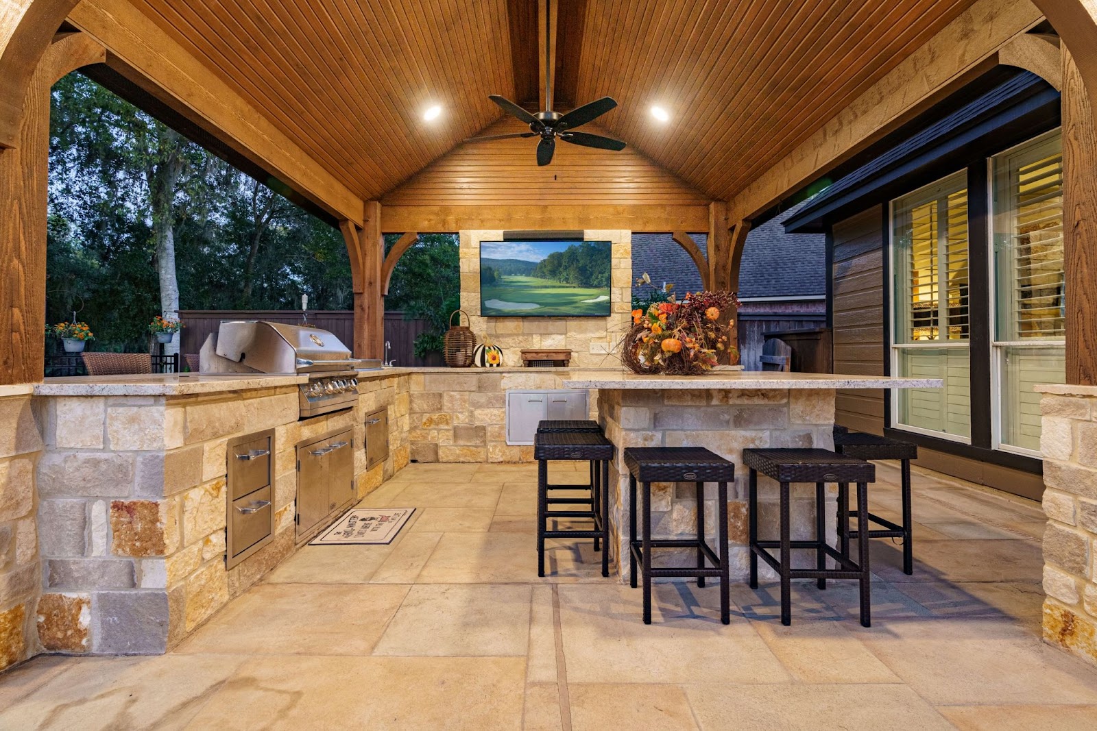 natural stone and wood outdoor kitchen design with island seating