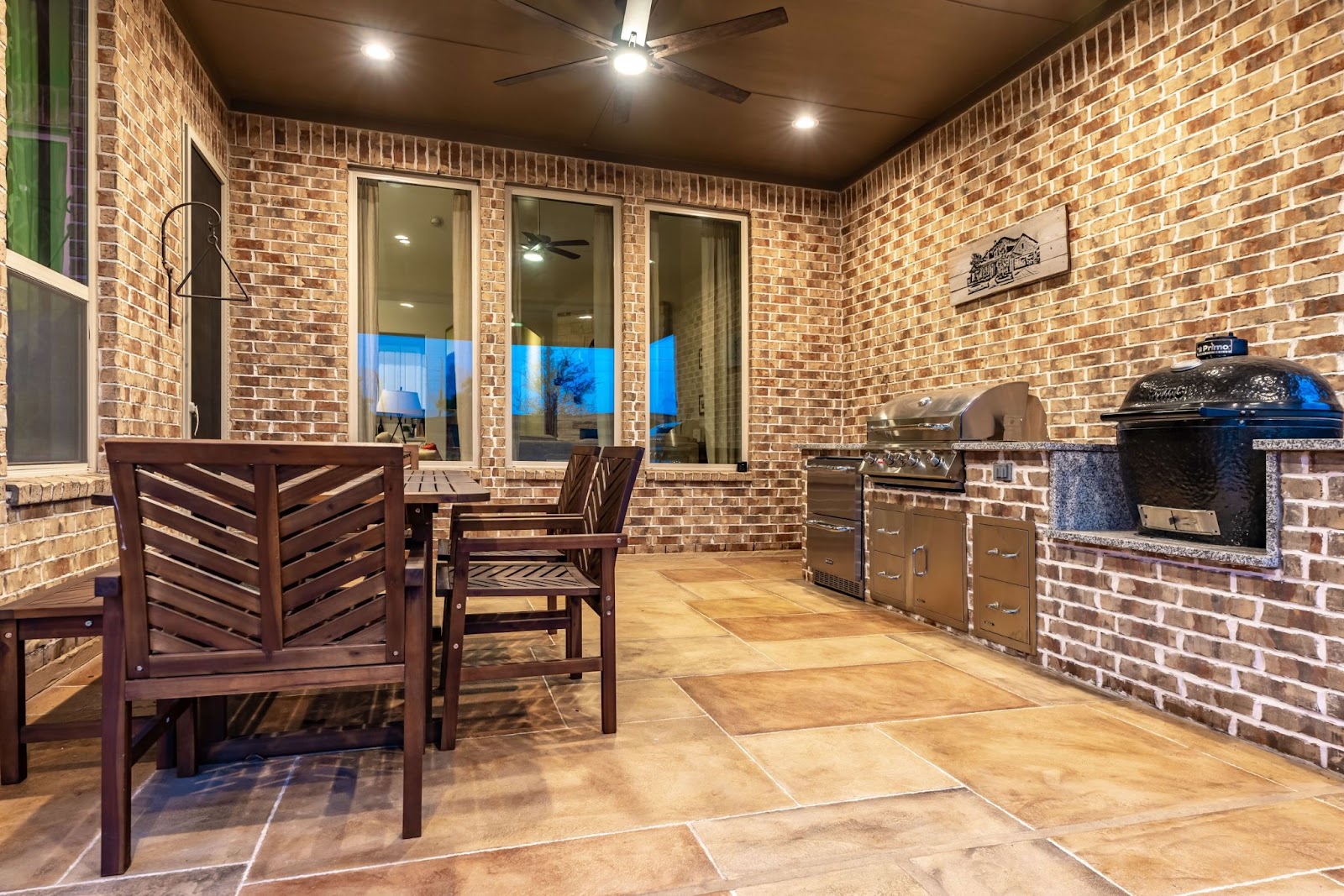 brick outdoor covered patio with grill island, cooktop and seating