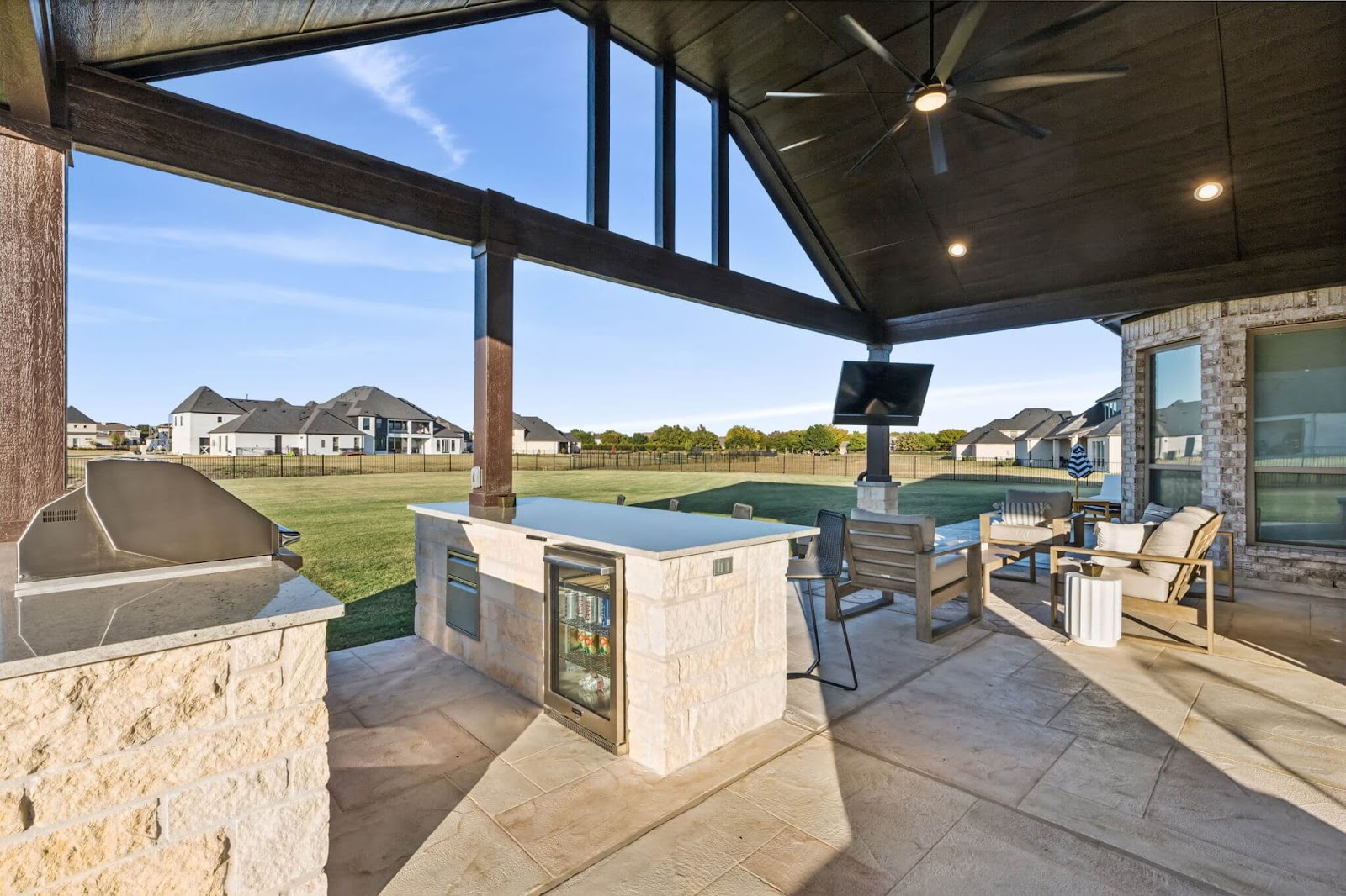 breezy transitional outdoor kitchen design gable roof patio with grill and fridge