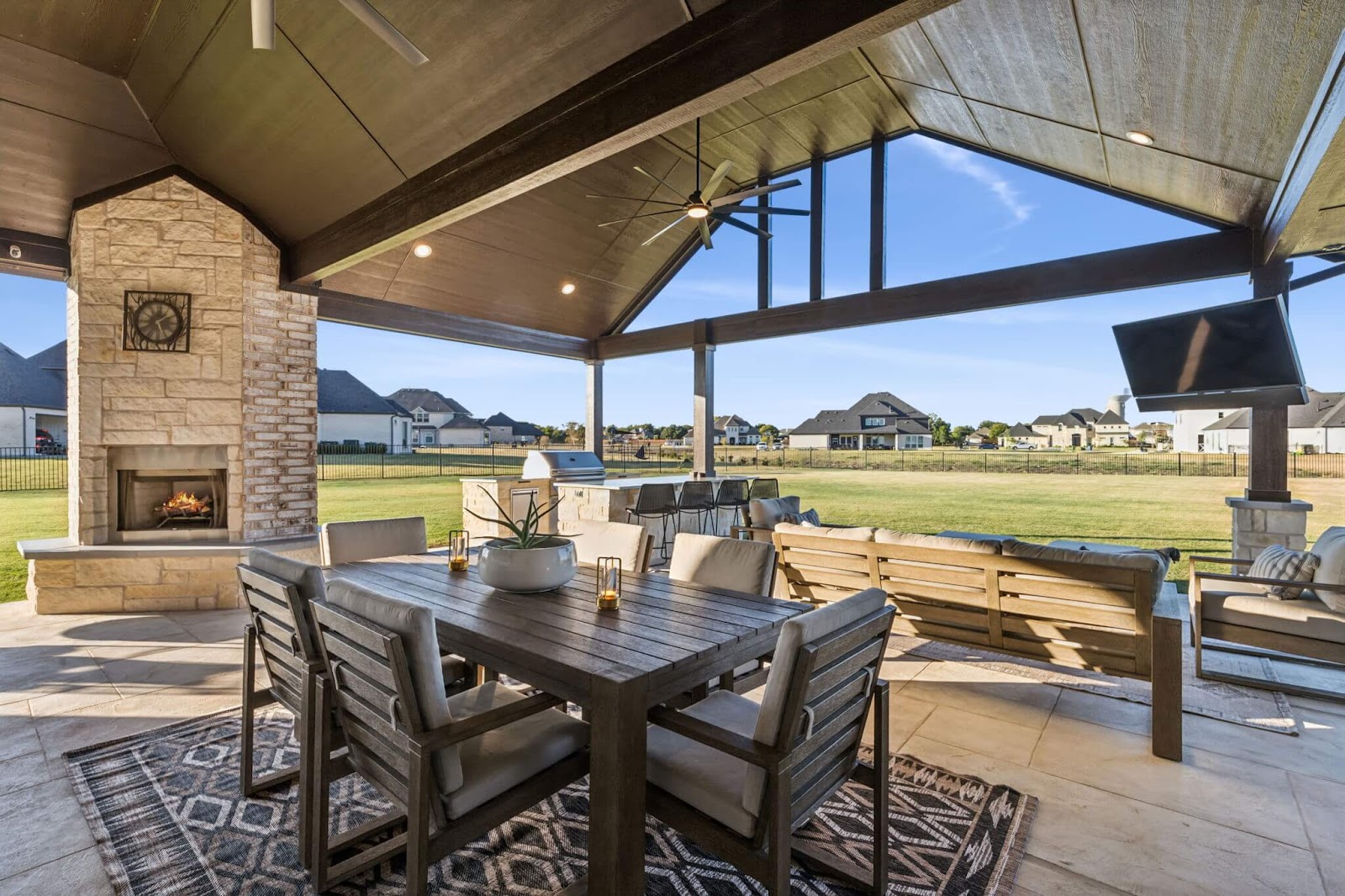 covered patio outdoor living room with gable roof and outdoor fireplace