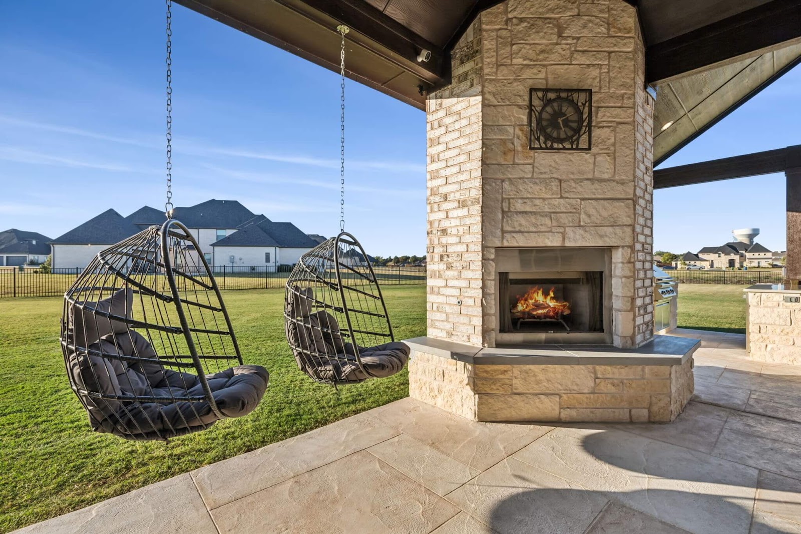 covered patio in texas backyard with grand pillar outdoor fireplace and mantle