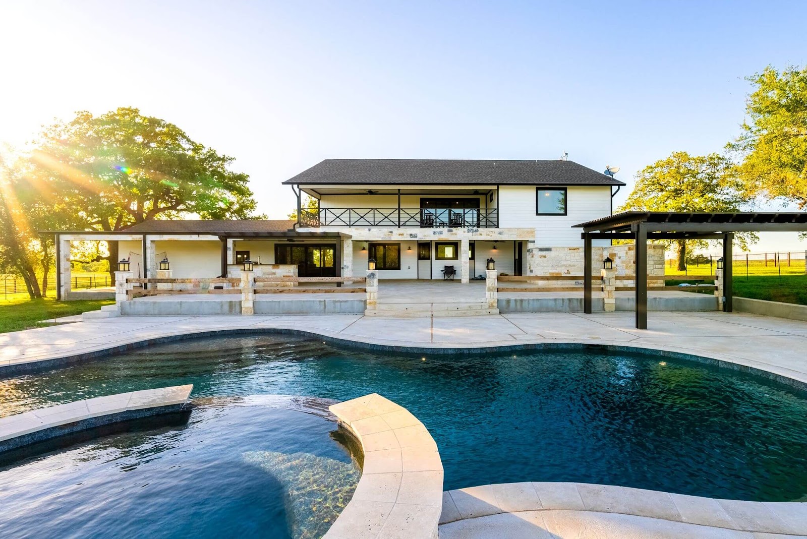 transitional pool deck design with white carvestone overlay and pergola