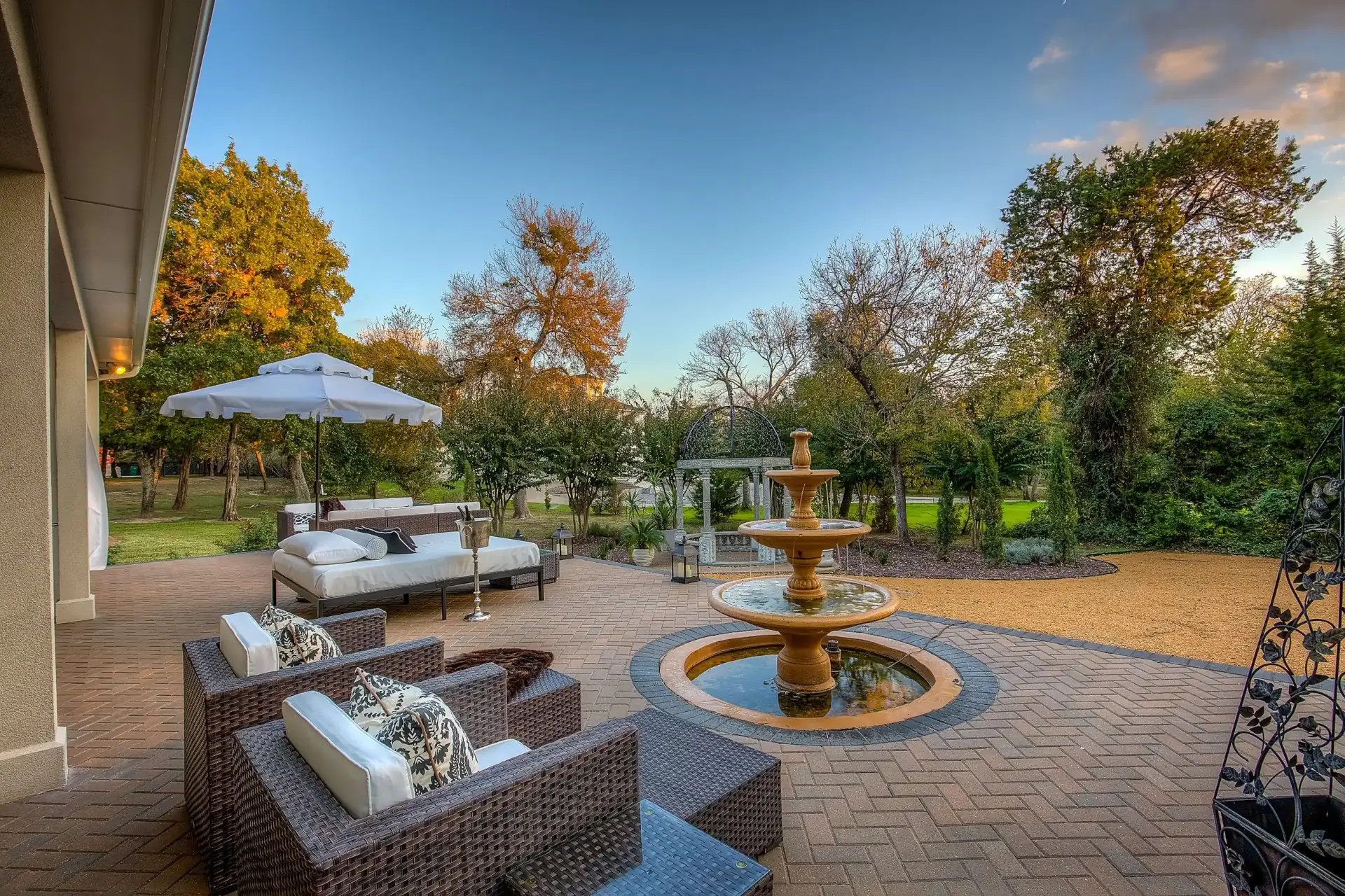 brick paver patio with outdoor lounge area and tiered outdoor water fountain