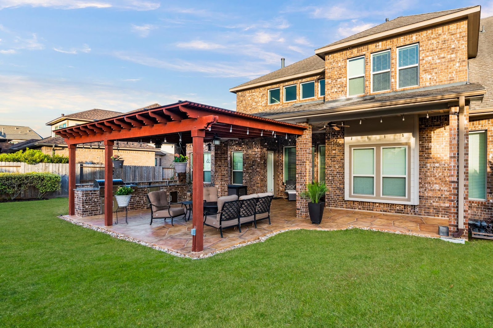 cedar louvered pergola attached to ATX home with carvestone patio flooring