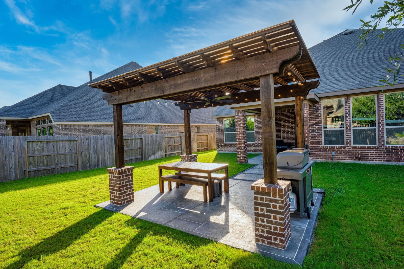 free standing wood and brick pergola with outdoor seating area