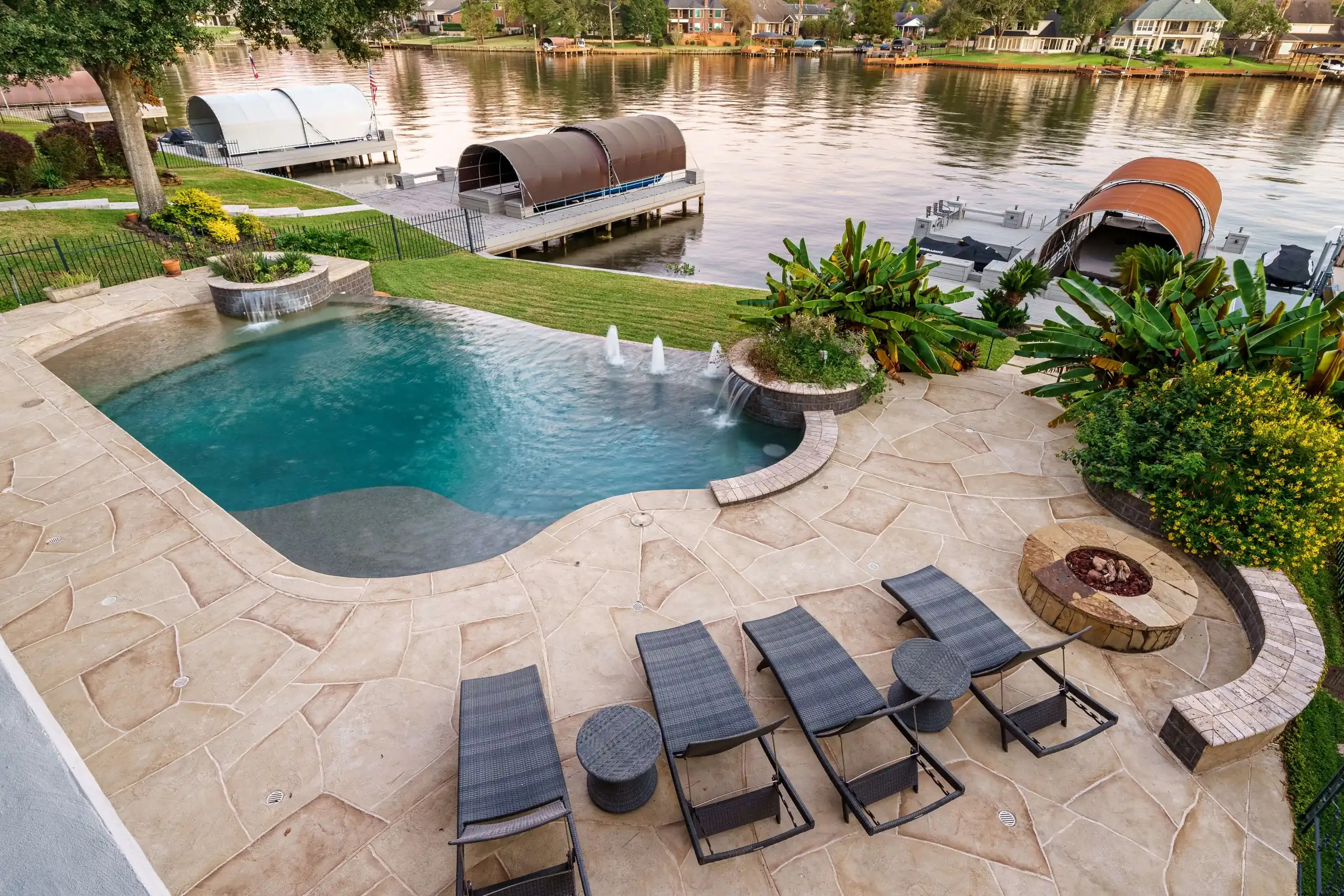 Texas riverside patio and pool deck with custom fire feature and swimming pool with vanishing edge