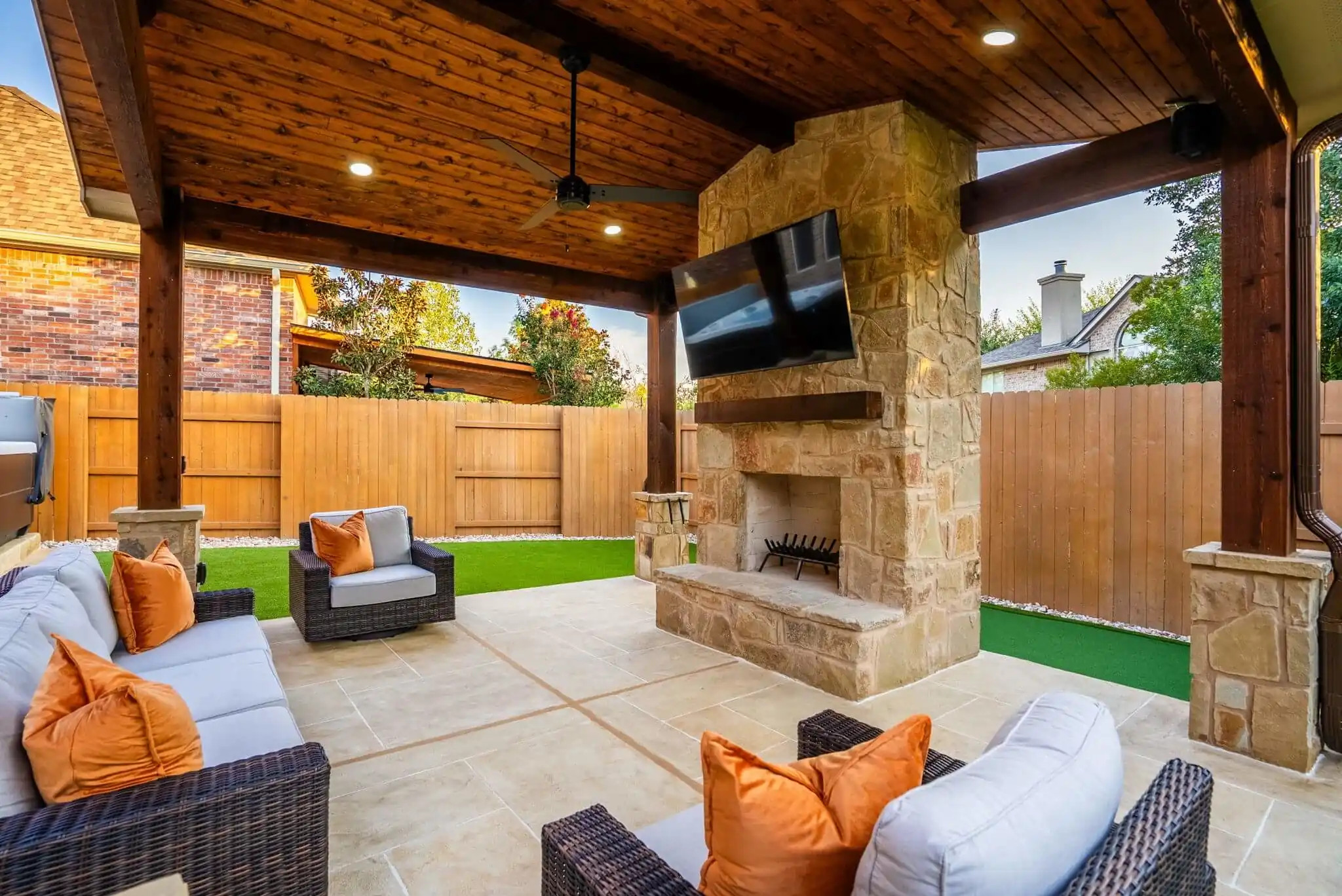 covered patio in Austin TX backyard with limestone and wood materials, custom fireplace