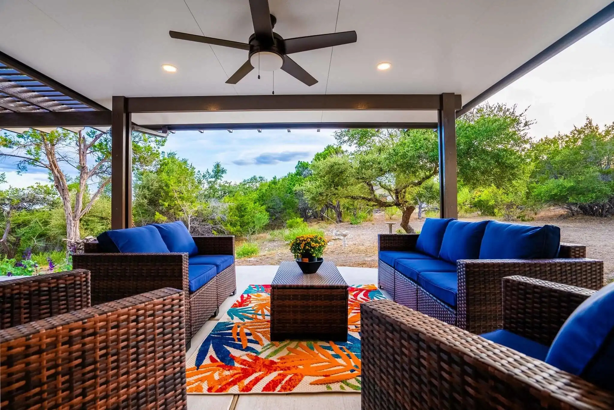 modern covered patio design with smart fan and recessed lighting and outdoor furniture