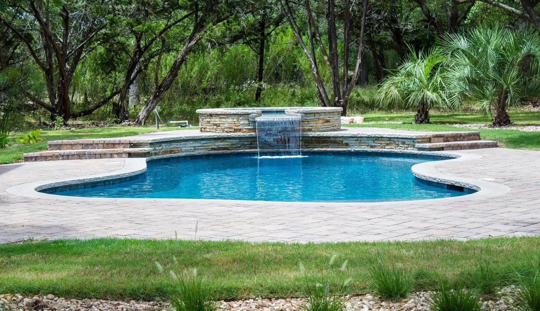 backyard oasis swimming pool and terraced spa with waterfall, texas