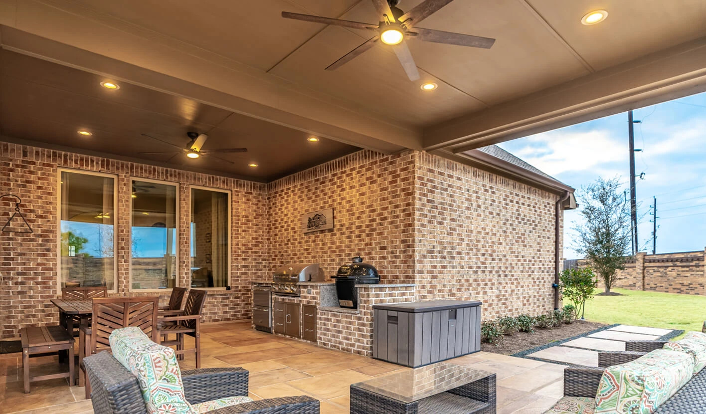 covered patio with attached roof structure on rustic brick ranch home in texas