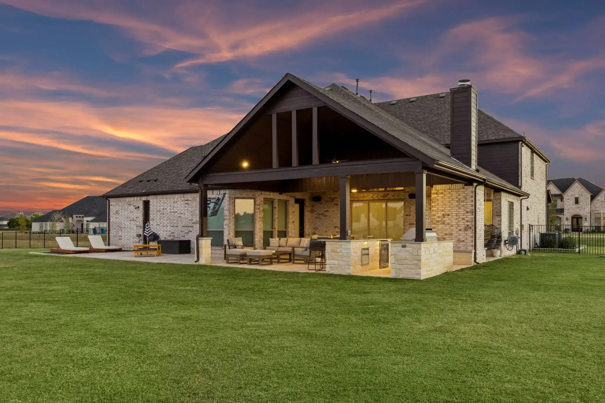 texas outdoor living space with gabled patio cover, outdoor kitchen and patio design