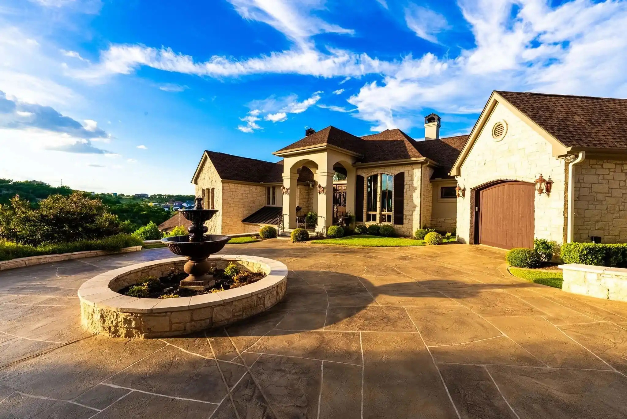 rustic concrete driveway with overlay materials in texas hill country